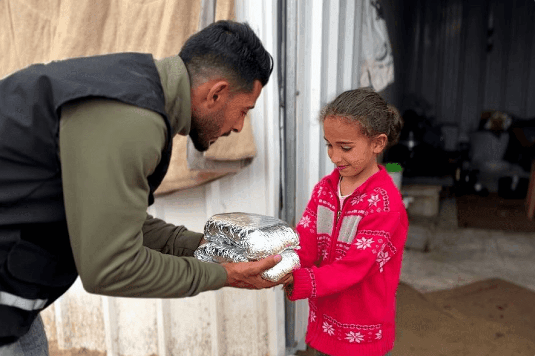 A displaced Palestinian girl receives a meal