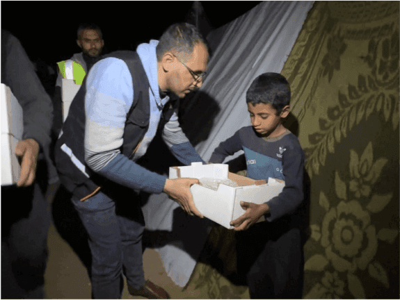 An emergency activist giving a food box to a displaced child affected by adversity